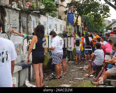 Caloocan City, Philippinen. 01.. November 2022. Filipinos zünden während des Allerheiligen-Tages Kerzen an und respektieren ihre Toten. Filipinos strömen nach zwei Jahren der Covid-19-Pandemie auf Friedhofs, da sich die Einschränkungen langsam lockern. Die Tradition, Blumen zu bringen, Kerzen anzuzünden und sogar Nahrung an der Begräbnisstätte ihrer verstorbenen Lieben anzubieten. (Foto: Josefiel Rivera/SOPA Images/Sipa USA) Quelle: SIPA USA/Alamy Live News Stockfoto