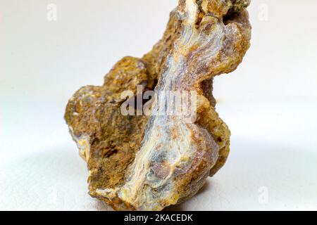 Glänzender echter roher Achatblock, brauner, gelber und weißer Achatchalcedon mit Achatdruse und kleinen Kristallsteinpunkten Makronah isoliert Stockfoto