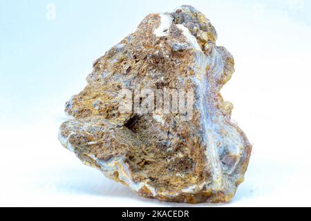 Glänzender echter roher Achatblock, brauner, gelber und weißer Achatchalcedon mit Achatdruse und kleinen Kristallsteinpunkten Makronah isoliert Stockfoto