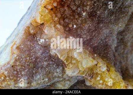 Glänzender echter roher Achatblock, brauner, gelber und weißer Achatchalcedon mit Achatdruse und kleinen Kristallsteinpunkten Makronah isoliert Stockfoto