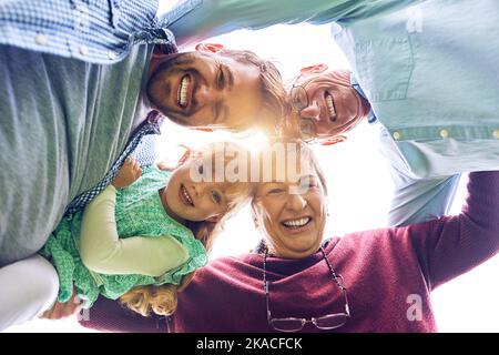 Glück liegt in der Stärke deiner Familie. Low-Angle-Aufnahme einer Familie mit mehreren Generationen im Freien. Stockfoto