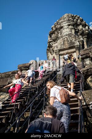 Angkor Wat, Kambodscha, 2. November 2022. Ausländische Touristen auf einer extrem steilen Treppe beim Besuch des inneren Turms im berühmten Angkor Wat in Kambodscha, 2. November 2022. Der Tourismus macht allmählich eine Wehr, mit rund 1.000 ausländischen Besuchern täglich, aber das ist immer noch nur ein Bruchteil der rund 6,5 Millionen, die 2019 vor der Covid-19-Pandemie besucht haben. Für die Touristen, die kommen, können sie eine einzigartige und nicht überlaufene Erfahrung haben, aber die lokale Wirtschaft, die so vom Tourismus abhängig ist, leidet weiterhin. Stockfoto