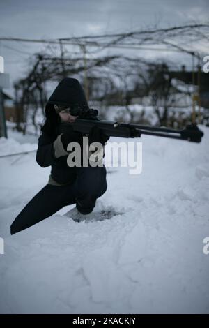 Eine schöne Frau hält Gewehr und zielen. Bereit zum Schießen, zielgerichtet schießen. Krieg, Armee, Technologie und Menschen Konzept Stockfoto