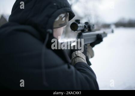 Eine schöne Frau hält Gewehr und zielen. Bereit zum Schießen, zielgerichtet schießen. Krieg, Armee, Technologie und Menschen Konzept Stockfoto