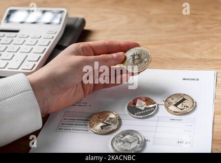 Bitcoin in Hand und Papier Rechnungsdokument. Zahlungen mit Kryptowährung im Geschäftskonzept. Stockfoto