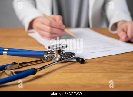 ARZT, DER EINEN KRANKENVERSICHERUNGSVERTRAG UNTERZEICHNET. Gesundheitsdokumente, Politikkonzept. Stockfoto