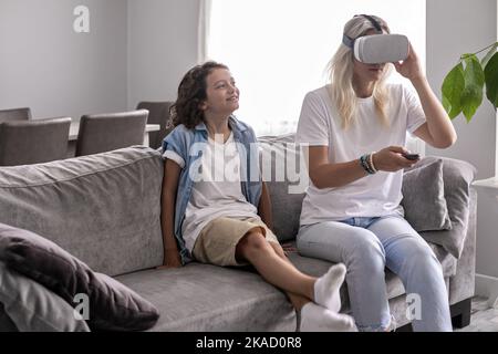 Junge Kind mit Mutter trägt Virtual-Reality-Headset vr Brille im Wohnzimmer zu Hause Spaß haben Stockfoto