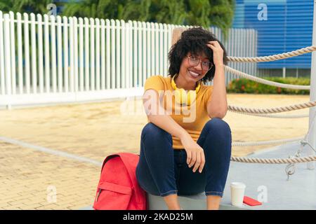 Afro-lateinamerikanische Frau, die im Park sitzt Stockfoto