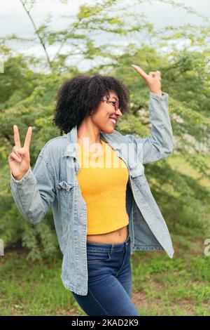 Lateinische Frau, die im Freien auf einem natürlichen grünen Hintergrund tanzt. Stockfoto