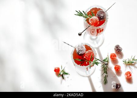 Weihnachts-Mimosa-Punsch oder Cranberry-margarita-Cocktail mit Cranberry-Saft, Orangenlikör und Champagner. Leckeres Eisgetränk für die weihnachtsfeiertage. Stockfoto