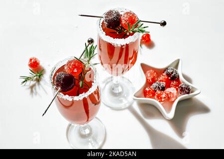 Weihnachts-Mimosa-Punsch oder Cranberry-margarita-Cocktail mit Cranberry-Saft, Orangenlikör und Champagner. Leckeres Eisgetränk für die weihnachtsfeiertage. Stockfoto