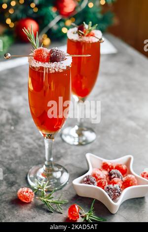 Weihnachts-Mimosa-Punsch oder Cranberry-margarita-Cocktail mit Cranberry-Saft, Orangenlikör und Champagner. Leckeres Eisgetränk für die weihnachtsfeiertage. Stockfoto