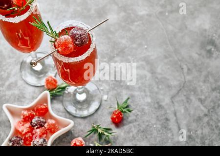 Weihnachts-Mimosa-Punsch oder Cranberry-margarita-Cocktail mit Cranberry-Saft, Orangenlikör und Champagner. Leckeres Eisgetränk für die weihnachtsfeiertage. Stockfoto