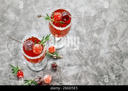 Weihnachts-Mimosa-Punsch oder Cranberry-margarita-Cocktail mit Cranberry-Saft, Orangenlikör und Champagner. Leckeres Eisgetränk für die weihnachtsfeiertage. Stockfoto