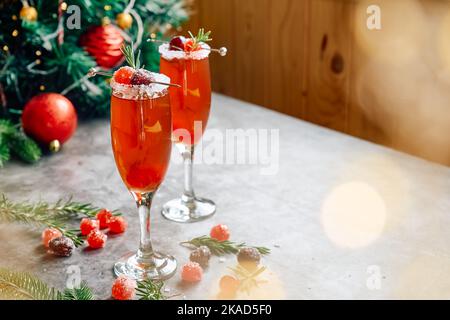 Weihnachts-Mimosa-Punsch oder Cranberry-margarita-Cocktail mit Cranberry-Saft, Orangenlikör und Champagner. Leckeres Eisgetränk für die weihnachtsfeiertage. Stockfoto