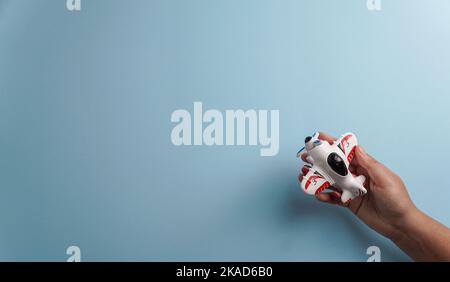 Hände mit Flugzeug, Lebensversicherung, Reiseversicherung, auf dem blauen Hintergrund, Familienschutz Stockfoto