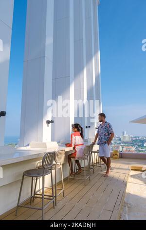 Ein paar Männer und Frauen besuchen ein Dachrestaurant mit Blick auf die Stadt Stockfoto