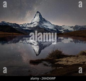 Matterhorn with milky way galaxy reflected in lake stellisee at night in switzerland. Stockfoto