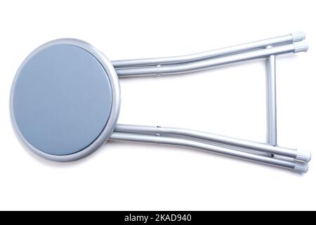 Zusammenklappbarer, gepolsterter, grauer, faltbarer Hocker auf weißem Hintergrund isoliert. Stockfoto