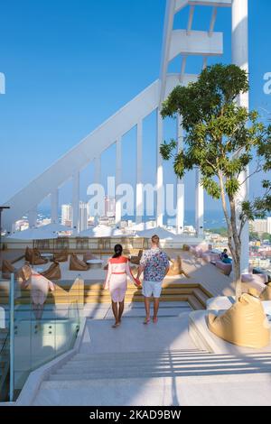 Ein paar Männer und Frauen besuchen ein Dachrestaurant mit Blick auf die Stadt Stockfoto