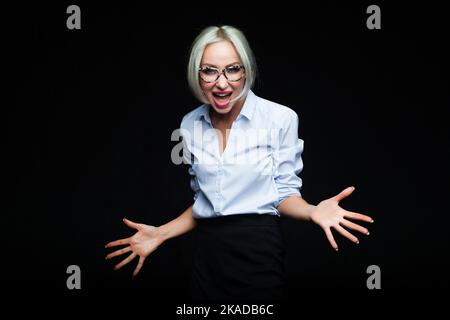 Junge emotionale Frau schreit auf schwarzem Studiohintergrund Stockfoto