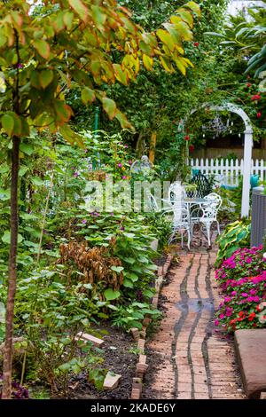 Salem, Massachusetts, USA - 3. September 2022: Ein gemauerter Pfad führt durch einen hübschen Garten, der von einem öffentlichen Bürgersteig aus gesehen wird. Stockfoto