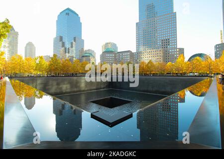 New York, NY - 28. Oktober 2022: Ground Zero 911 World Trade Center Gedenkstätte mit Reflexionen von Gebäuden in der Nähe. Stockfoto