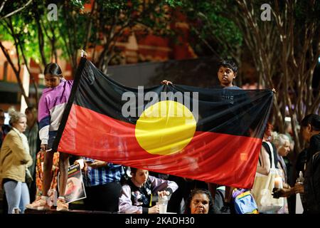 Die Kinder tragen am 2. November 2022 bei einer Mahnwache bei Kerzenlicht in Brisbane eine Flagge der Aborigines für Cassisus Turvey, der angeblich im Oktober bei einem rassistischen Angriff in Perth ermordet wurde. Demonstranten versammelten sich in Brisbane zu einer Mahnwache bei Kerzenlicht für den indigenen Teenager Cassius Turvey, der während eines rassistischen Angriffs angegriffen wurde, als er letzten Monat von der Schule in Perth, Westaustralien, heimging. Der 15-jährige Turvey starb zehn Tage später am 23.. Oktober an seinen Wunden. Demonstranten in vielen Städten und Gemeinden im ganzen Land forderten gleichzeitig Maßnahmen gegen rassistisch motivierte Gewalt und Arme Stockfoto
