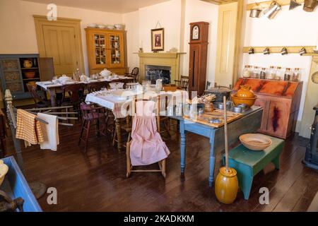 Antike Tische, Stühle und Küchenutensilien in einem Speisesaal im Cove Creek Ranch Fort, erbaut 1867, Cove Fort, Utah. Stockfoto