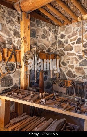 Eine Bohrpresse und andere Werkzeuge in der Schmiede im Pioneer Cove Creek Ranch Fort, erbaut 1867, Cove Fort, Utah. Stockfoto