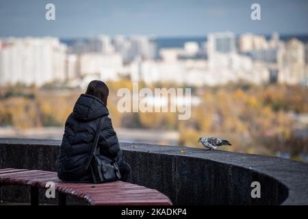 28. Oktober 2022, Kiew, Ukraine: Mädchen sitzt auf einer Bank in einem Park im Zentrum von Kiew. Im Oktober 2022 führten die russischen Streitkräfte zahlreiche Angriffe auf die zivile Infrastruktur von Kiew durch, die massive Stromausfälle, Wasserversorgung und Heizung in der Stadt verursachten. (Bild: © Oleksii Chumachenko/SOPA Images via ZUMA Press Wire) Stockfoto