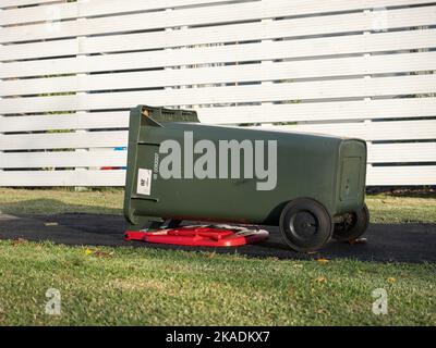 Blick auf Mülltonnen, die von starkem Wind auf dem Boden gestürzt wurden Stockfoto