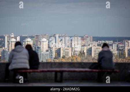 28. Oktober 2022, Kiew, Ukraine: In einem Park im Zentrum von Kiew sitzen Menschen auf einer Bank. Im Oktober 2022 führten die russischen Streitkräfte zahlreiche Angriffe auf die zivile Infrastruktur von Kiew durch, die massive Stromausfälle, Wasserversorgung und Heizung in der Stadt verursachten. (Bild: © Oleksii Chumachenko/SOPA Images via ZUMA Press Wire) Stockfoto