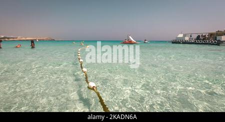 Im Meer schwimmende Markierungsbojen. Türkisfarbenes Wasser und goldener Sand am Nissi Beach, Zypern. Stockfoto