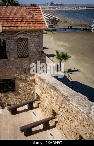 Larnaca, Zypern - 25. Juni 2022: Mittelalterliche Festung Larnaca. Alte Kanonen und Befestigungsanlagen, Finikoudes-Strand im Hintergrund. Stockfoto