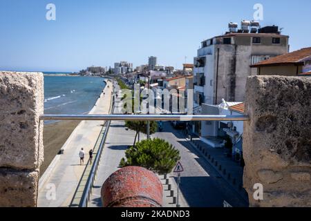 Larnaca, Zypern - 25. Juni 2022: Blick vom mittelalterlichen Fort Larnaca auf die Straße und das Meer. Kanonenfass im Vordergrund. Stockfoto