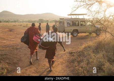 MASSAI MIT REISETASCHEN VON TOURISTEN Stockfoto