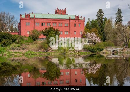 Die neugotische Burg in Klasterec nad Ohri spiegelte sich an einem sonnigen Frühlingstag im Fluss Ohre wider Stockfoto