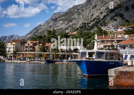 Kotor, Montenegro - 29. April 2022: Segelyachten, Motorboote und kleine Fischerboote liegen am Pier in der Bucht von Kotor vor. Berge im Hintergrund. Stockfoto