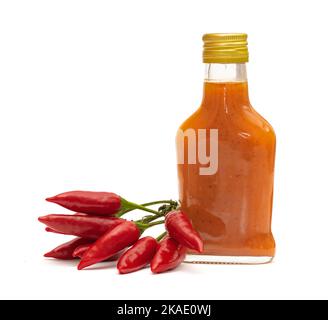 Flasche mit hausgemachter Chili-Peperesauce und frischen Tabasco-Paprika auf weißem Hintergrund Stockfoto