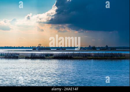 Gegen den Sonnenuntergang. Marano Lagune Spätsommer Farben. Wolken und Sonne Stockfoto