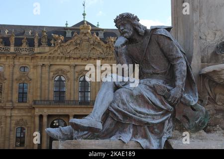 Skulptur des Minnesängers Walter von der Vogelweide am Franconiabrunnen auf dem Platz vor der Residenz in Würzburg Stockfoto