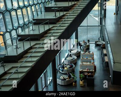 Reykjavik, Island - 23. März 2022: Gäste im Restaurant im Konzertsaal Harpa. Moderne Architektur, farbenfrohe Glaswände. Stockfoto