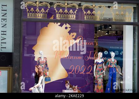 Am ersten Tag des Platinum Jubilee Weekends läuft ein Fußgänger an einer Dekoration des Platinum Jubilee auf dem Schaufenster einer Einzelhandelseinheit in London vorbei. Stockfoto