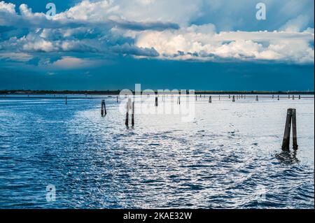 Gegen den Sonnenuntergang. Marano Lagune Spätsommer Farben. Wolken und Sonne Stockfoto