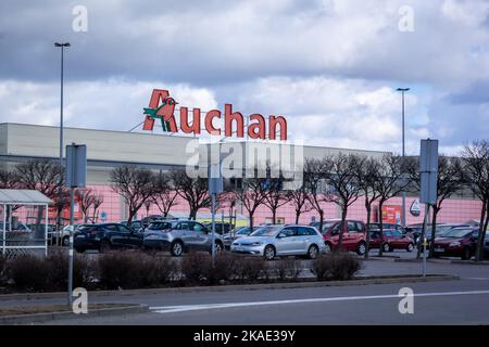 Breslau, Polen - 19. Februar 2022: Französischer Supermarkt Auchan und Parkplatz vor dem Einkaufszentrum. Stockfoto