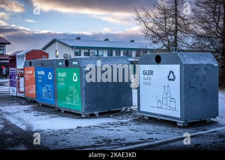 Reykjavik, Island - 20. Januar 2022: Eine Reihe von bunten Müllcontainern auf der Straße. Abfalltrennung. Schneereichen Wintertag, keine Menschen. Stockfoto
