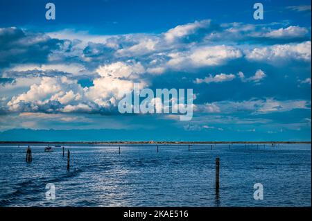 Gegen den Sonnenuntergang. Marano Lagune Spätsommer Farben. Wolken und Sonne Stockfoto