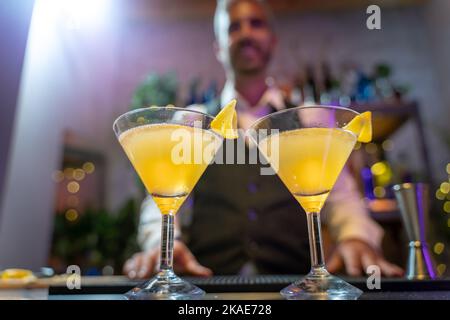Der Barkeeper serviert zwei Cocktails an der Theke im Nachtclub. Stockfoto