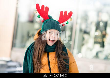 Foto von lustigen funky Schule Mädchen gekleidet outwear Mantel x-Mas Haarband winken im Freien Stadt Straße Stockfoto